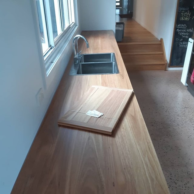 Narrow timber kitchen bench-top with cutting board on it